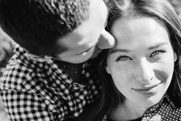 Hermosa chica mirando a la cámara mientras su novio se besa — Foto de Stock