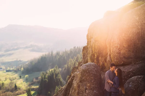 Romantisches Paar steht auf den Felsen und umarmt sich in den Bergen — Stockfoto