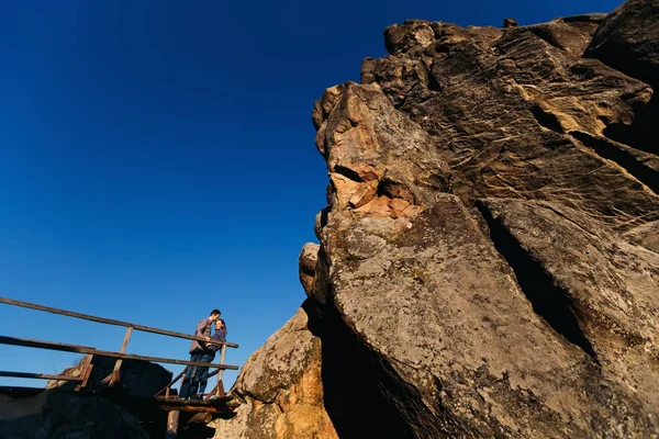 巨大な巨大な岩で素敵なカップルの立っています。 — ストック写真