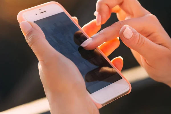 Detailní záběr na ženské prsty posouvání fotografie na telefonu. Dívka h — Stock fotografie