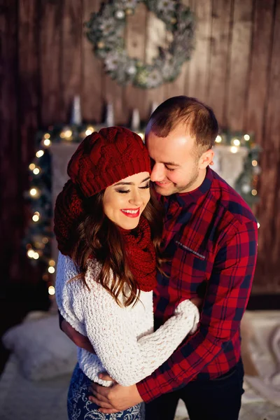 Beautiful young couple on nicely decorated Christmas garlands ba — Stock Photo, Image