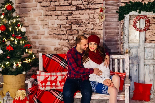 Bom casal sentado no banco em um sótão decorado para o Natal — Fotografia de Stock