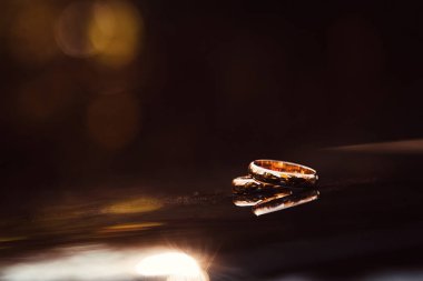 İki altın arka plan bulanık ile karanlık yüzeyinde döşeme alyans