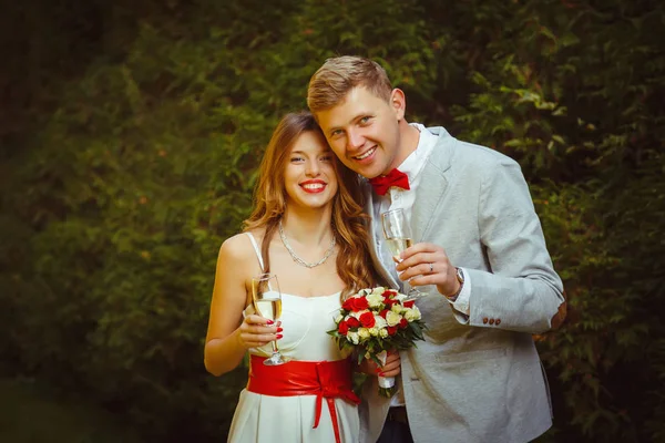 Feliz casal sorrindo bebendo champanhe de seus óculos — Fotografia de Stock