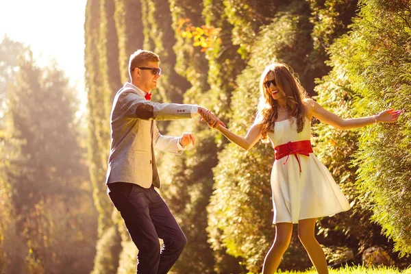 Casal feliz se divertindo, dançando e jogando no parque de outono — Fotografia de Stock