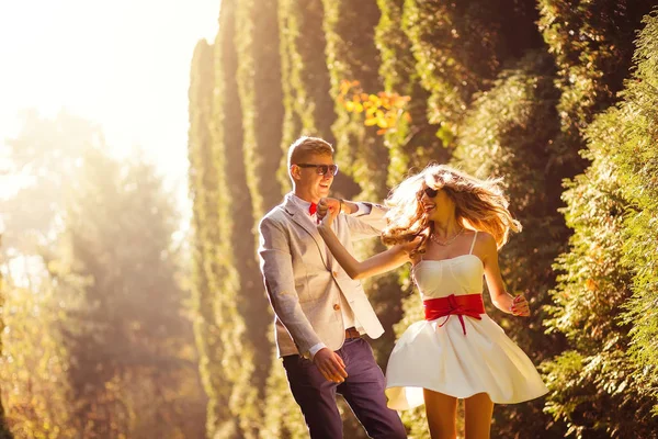 Жінка крутиться в її білій короткій сукні перед її стильним чоловіком — стокове фото