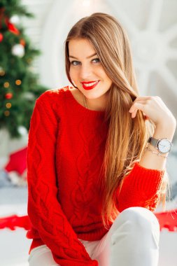 Keyif-in onun blo tutarak sıcak kırmızı kazaklı gülümseyen kadın modeli