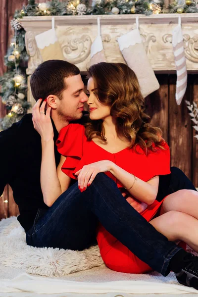 Elegant couple sitting near chimney on new year eve — Stock Photo, Image