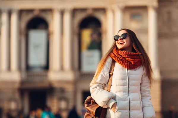 Lachende meisje in zonnebril draagt witte jas en een oranje — Stockfoto