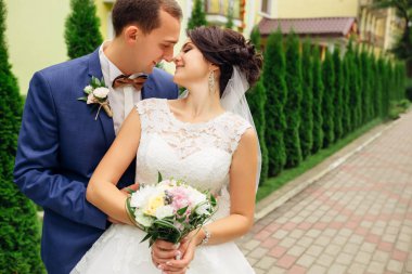 Gülümseyen ve burunlarını dokunmadan mutlu çift. Gelin holding bou