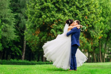 Güzel düğün çifti çayır öpüşme spin. Damat ve b