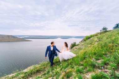 Güzel düğün çifti muhteşem bir koy, romantik bir yürüyüş. 