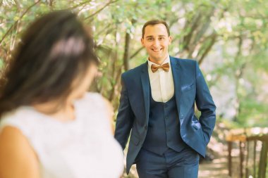 Gülümseyen eşi çalışan damat. Gelinin arkasından bak 