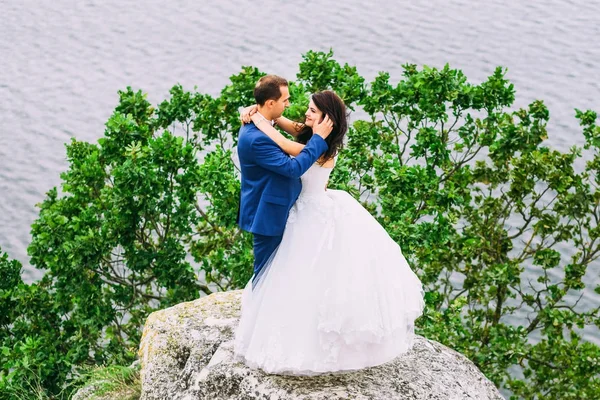 Couple de mariage étreignant sur le rocher — Photo