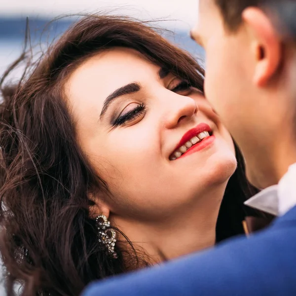 Brunette bruid met mooie glimlach kijkt gelukkig in de liefde haar h — Stockfoto