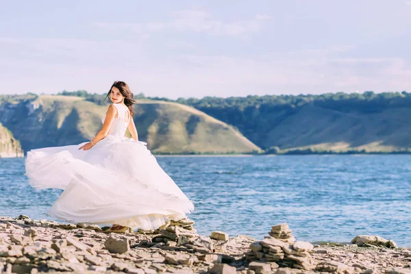 Bela noiva de luxo vestido branco girando ao redor no lago — Fotografia de Stock