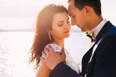 Güzel çift günbatımı closeup gölde, sarılma