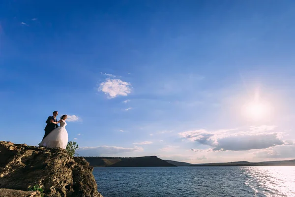 Fantástica pareja de boda en el pintoresco paisaje en un mar — Foto de Stock