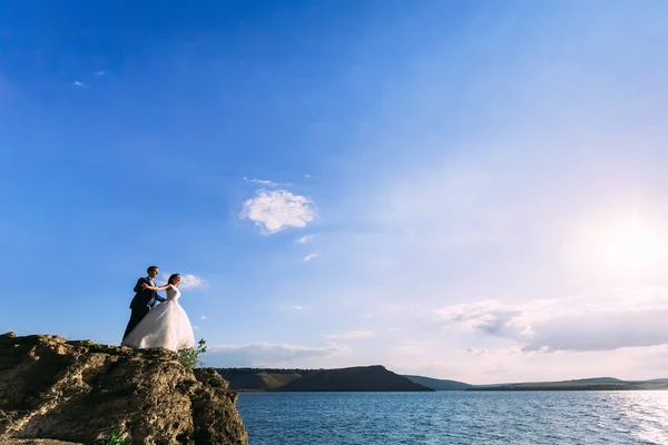 Fantástica pareja de boda en el pintoresco paisaje en un mar — Foto de Stock