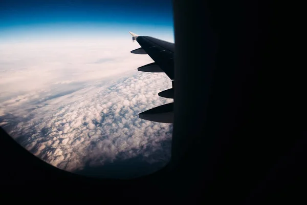 Visa från planet på moln under och tydlig mörkblå himmel ovanför. — Stockfoto