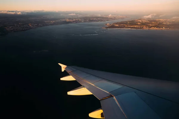 Vliegtuig vleugel boven water in zonlicht voor de landing — Stockfoto