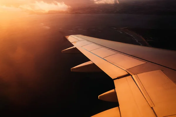 Vliegtuig vleugel in zonsondergang lichten voor de landing — Stockfoto