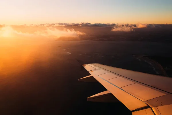 Asa de avião em luzes de pôr do sol antes de pousar na Itália — Fotografia de Stock