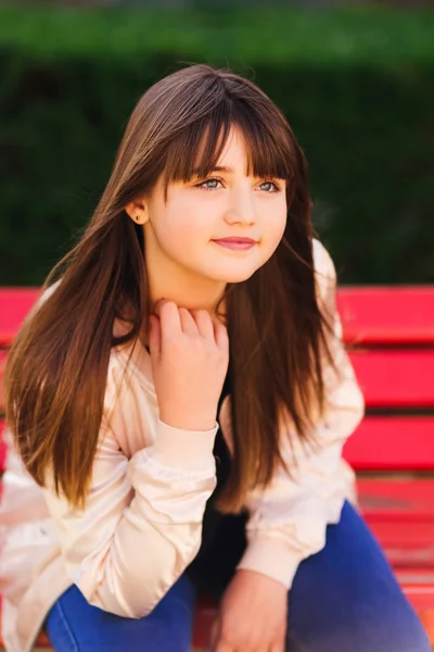 Hermosa chica con grandes ojos sentados en el banco — Foto de Stock