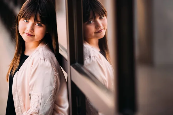 Hermosa adolescente primer plano inclinándose a la ventana con su reflejo — Foto de Stock