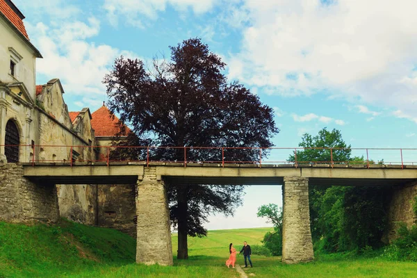 Onunla el ele tutuşarak Turuncu elbiseli hamile güzel kadın 