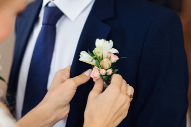 Gelinin eli damadın ceketine yaka çiçeği takar.