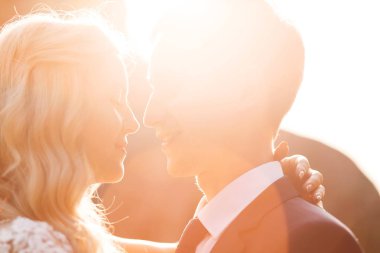 Birbirine bakarak şefkat ve sevgi ile güneş üzerinde yeni evliler