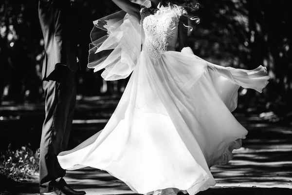 Sposa in abito da sposa di lusso che gira intorno di fronte allo sposo . — Foto Stock