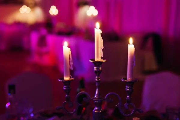 Três velas iluminando em um restaurante de luxo em uma véspera oficial — Fotografia de Stock
