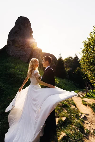 Bella sposa con i capelli biondi ricci in posa davanti al suo sposo — Foto Stock
