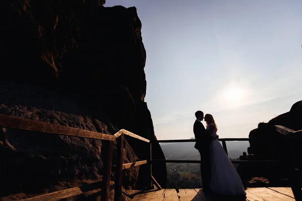 Το ζευγάρι η νύφη και ο γαμπρός που φαίνονται σε κάθε άλλο στο ηλιοβασίλεμα σε t — Φωτογραφία Αρχείου