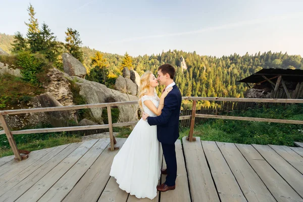 Zärtlich küssendes Paar gegen Felsen und fernen Herbstwald — Stockfoto