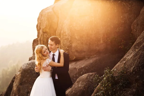 Güzel düğün çift usulca onlara ışık saçan güneş ile sarılma