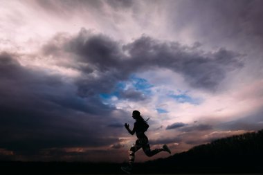 Jogging arka planda çalışan ve yapıyor atletik kız egzersizleri 