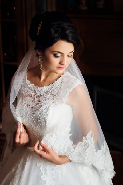 Nádherná nevěsta drží její závoj kolem jejího těla — Stock fotografie