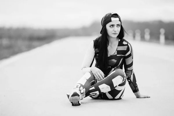 Einsame Frau in Sportkleidung sitzt auf dem Asphalt und denkt nach — Stockfoto