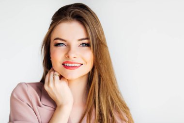 Sarışın güzel kız kameraya bakarak ve beyaz üzerinde gülümseyen