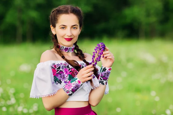 Beautiful ukrainian teen holding lupine in her hand — Stock Photo, Image