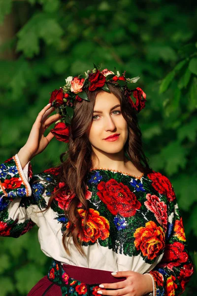 花輪とカラフルなビーズが刺繍されたドレスの若い女性 — ストック写真