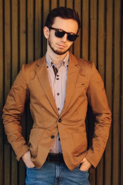 Kot pantolon ve kahverengi ceket giyen ciddi adam elinde Merhaba tutar