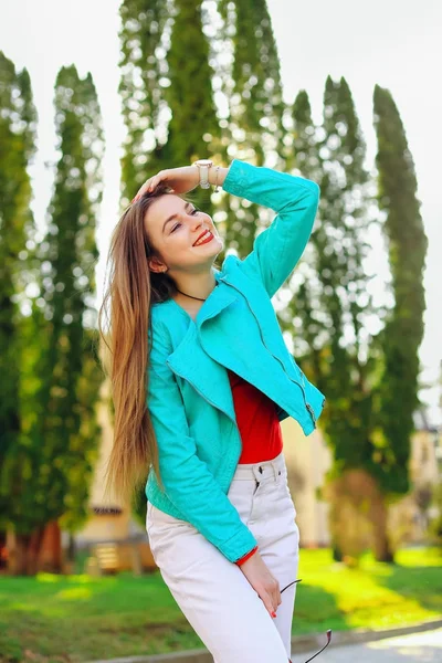 Stylische junge Frau mit langen blonden Haaren lächelt und hält ihren — Stockfoto