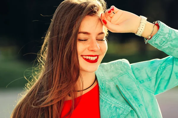 Souriante jeune femme aux lèvres rouges se sentant heureuse à la lumière douce à — Photo