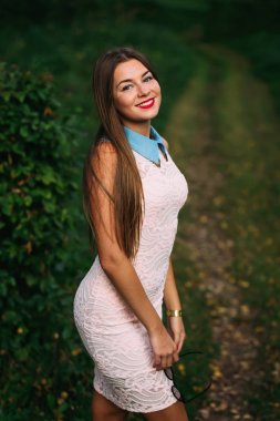 Pastel elbiseli güzel genç kadın kameraya benziyor