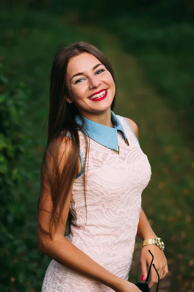 Schitterend meisje met lang haar dragen van pastel jurk ziet er in de — Stockfoto