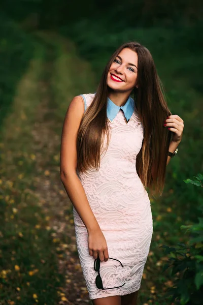 Очаровательная девушка с длинными волосами улыбается в камеру — стоковое фото